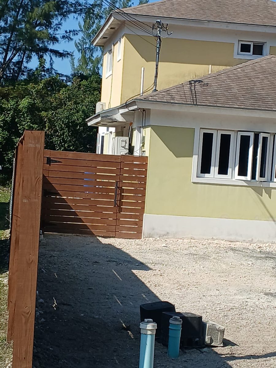 Yellow and green home with new wood fence