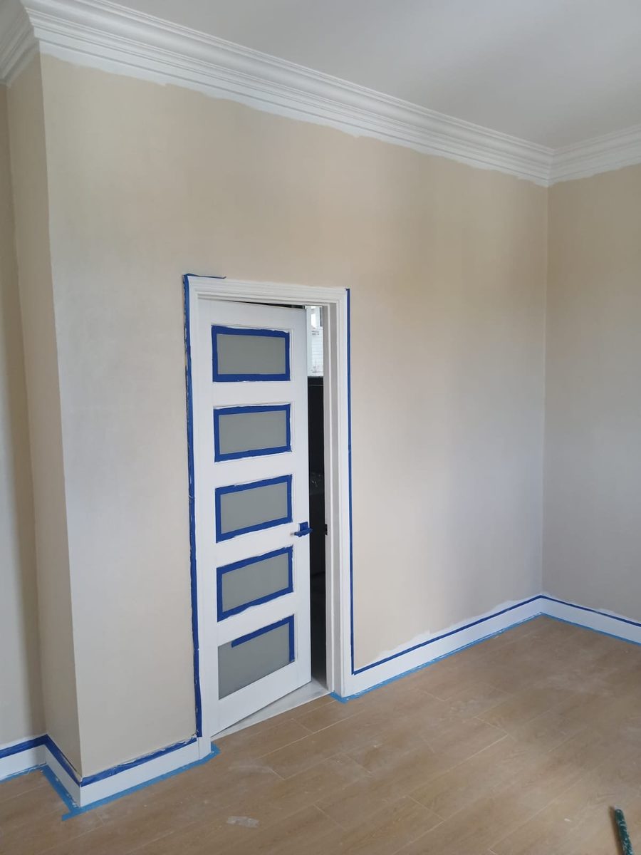 Interior room with painted panel door and crown molding