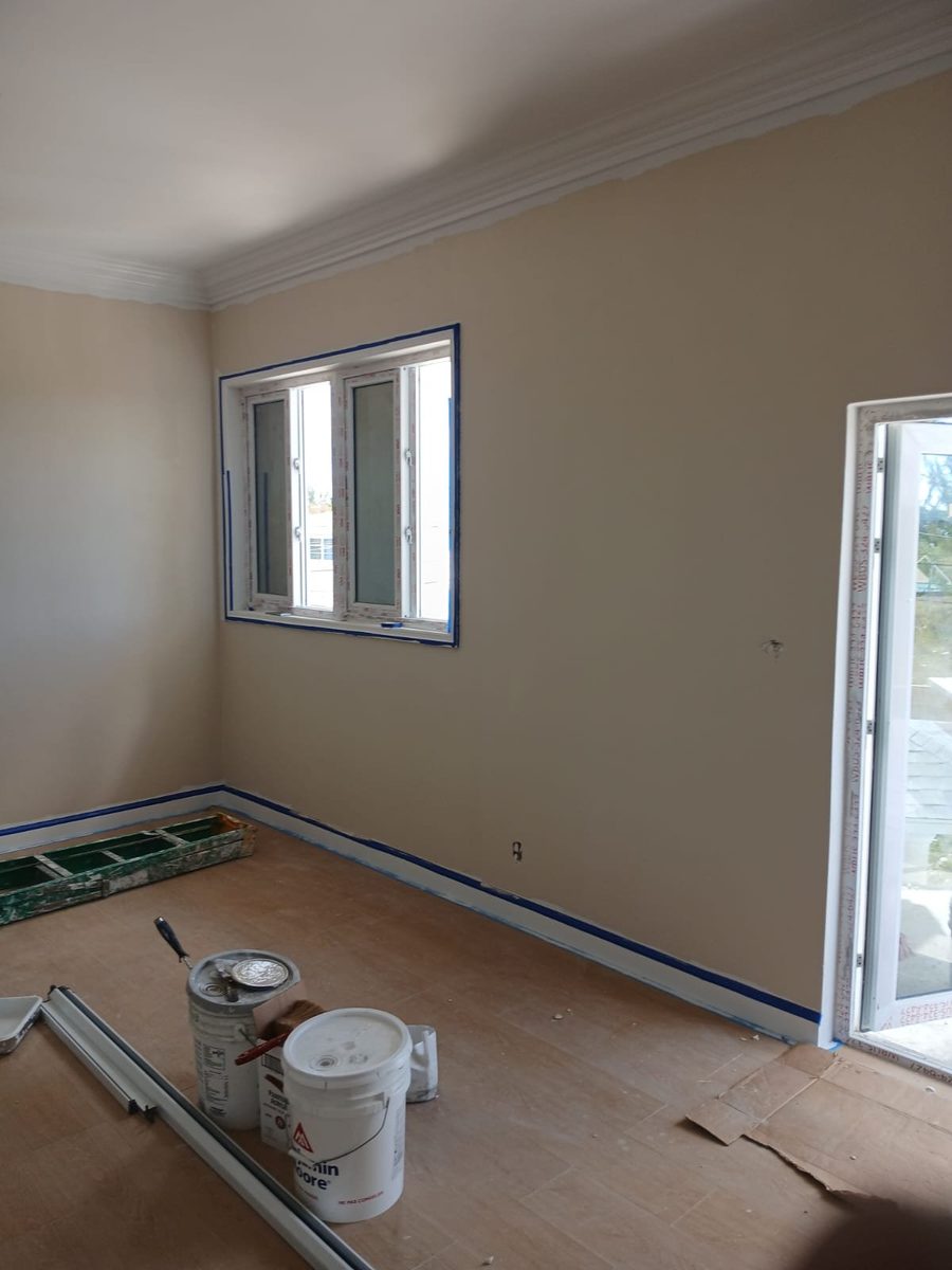 Interior wall painted warm tan with taped window trim