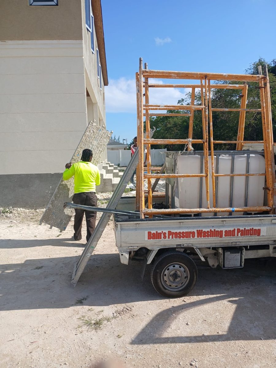 Worker loading scaffold onto a branded company truck
