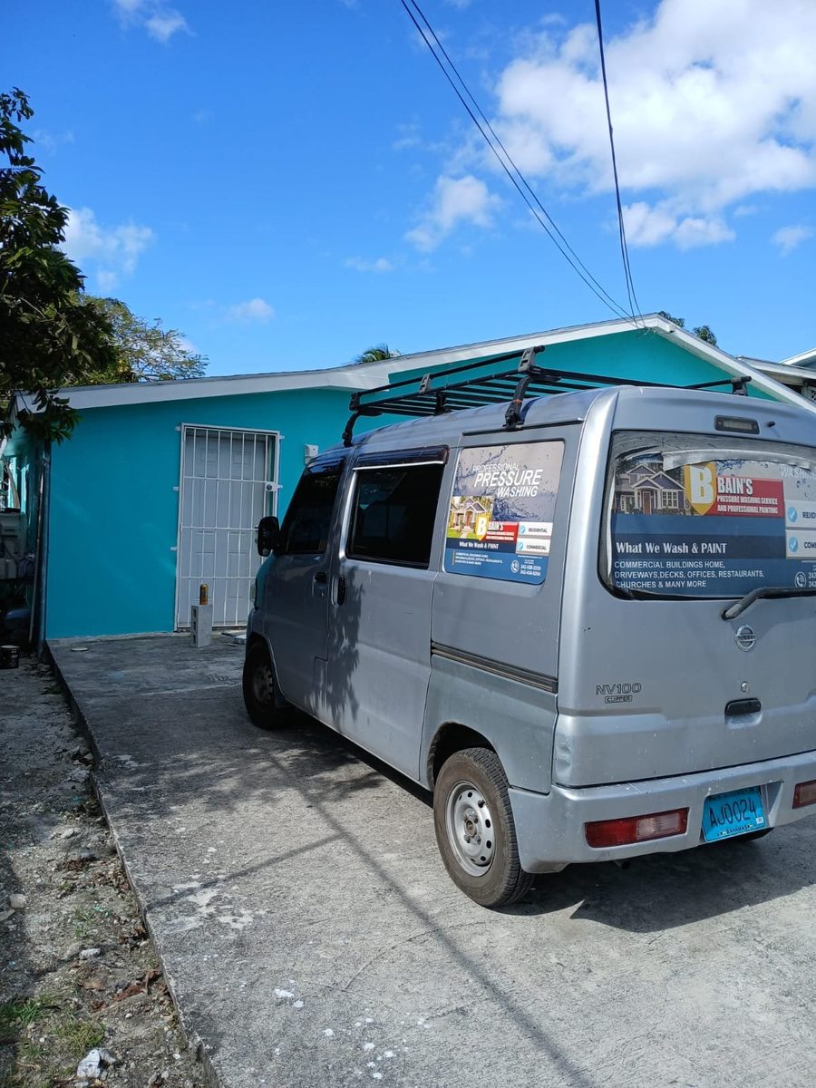 Branded company van parked at a finished teal home